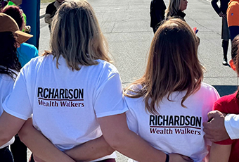 Kelly Milne and guest with arms around each other's shoulders at the starting line. Their t-shirts say Richardson Wealth Walkers.